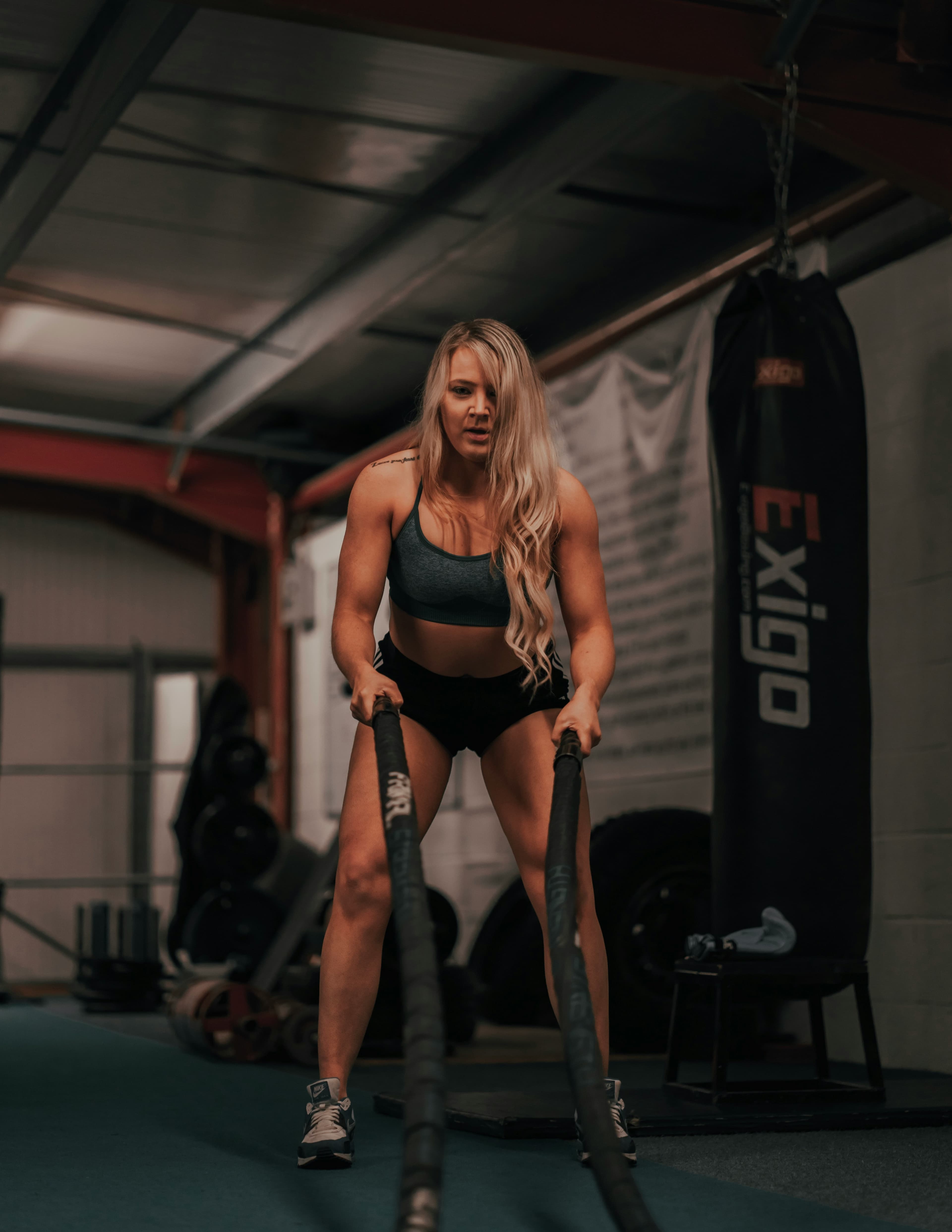 Sarah Martinez - HIIT Instructor demonstrating battle rope exercises